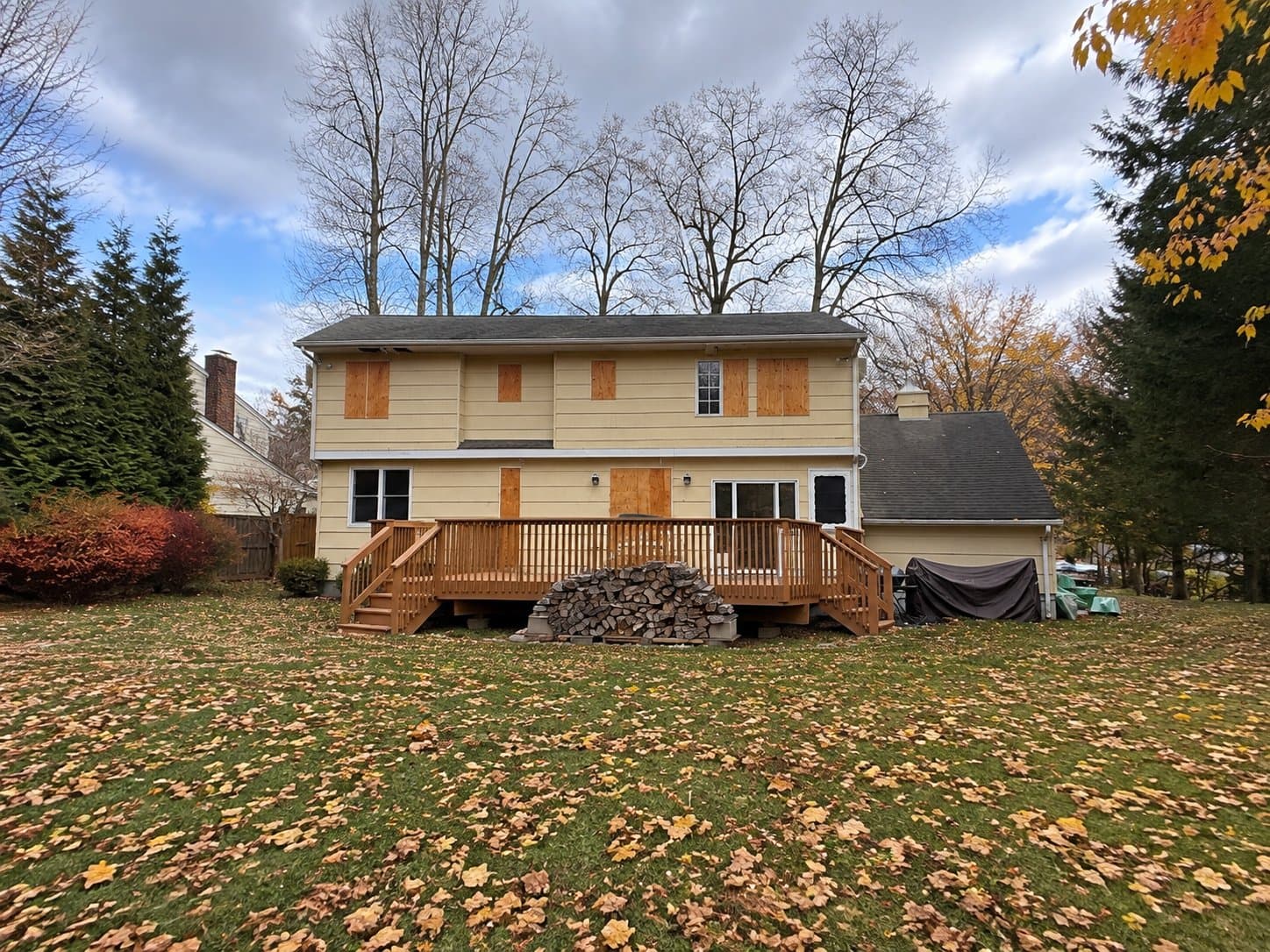 Hillside · Before: The back of the house before the work, plywood over the openings and an old wood deck.