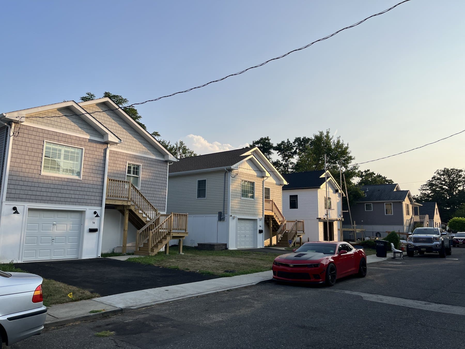 After: Raised homes on the same street, each with a garage underneath and a stair to the entry.