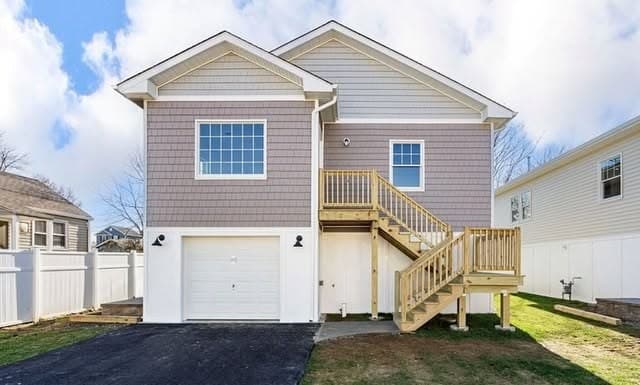 A raised home with a new garage beneath and entry stair, finished.
