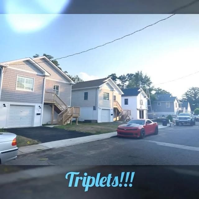 Three raised homes side by side on one street, captioned "Triplets!!!" on our Instagram.